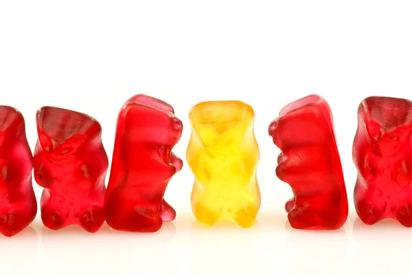 Řada červený Gumový medvědy a jediný žlutý — Stock fotografie