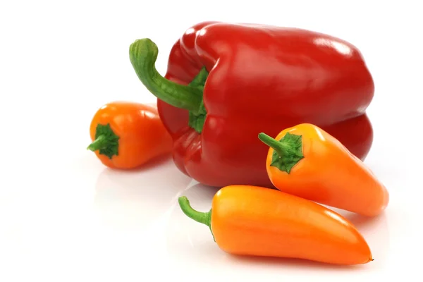 A fresh red and some orange peppers — Stock Photo, Image