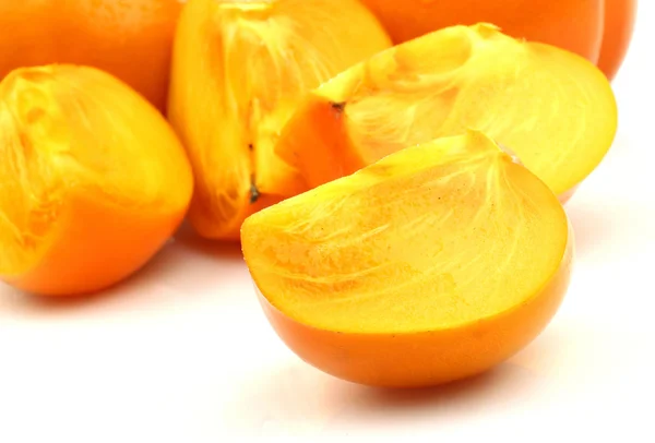 Twee persimmon fruit en een gesneden — Stockfoto