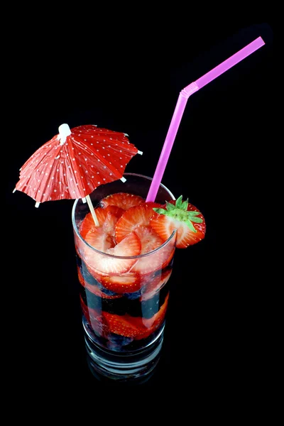 stock image Long drink glass with summer fruits, a straw and a cocktail umbrella