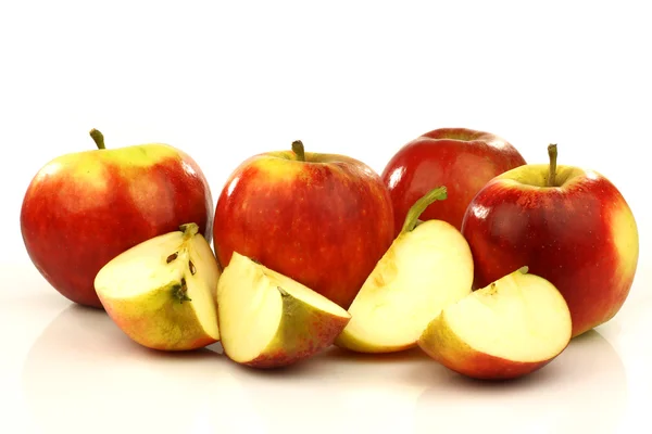 Some whole and some cut red and yellow apples — Stock Photo, Image