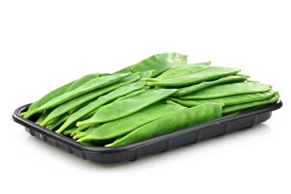 黒いプラスチック製のトレイに緑色のエンドウ豆の鞘 — ストック写真