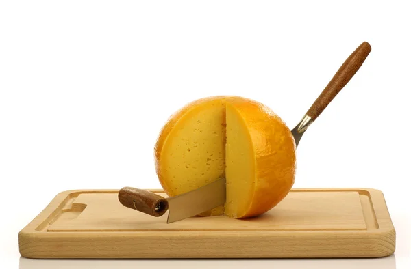 Couteau à fromage avec des morceaux coupés de fromage Edam néerlandais sur une planche à découper — Photo