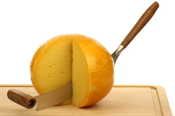 Μαχαίρι τυριού με κάποια κομμάτια κομμένα ολλανδικό τυρί Ένταμ σε ένα ξύλο κοπής — Φωτογραφία Αρχείου