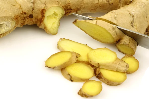 Cut pieces of fresh ginger with a knife — Stock Photo, Image