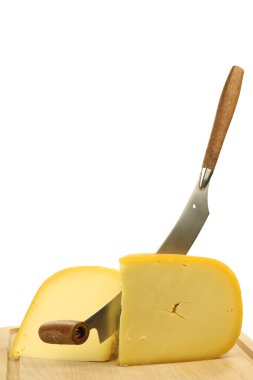 Traditional Gouda cheese pieces with a cheese cutter clipart