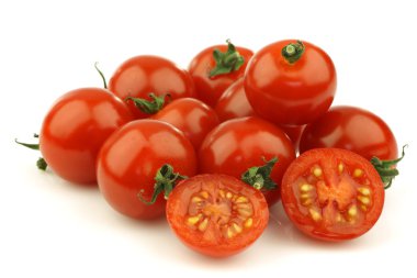 Fresh cherry tomatoes on the vine with one cut clipart