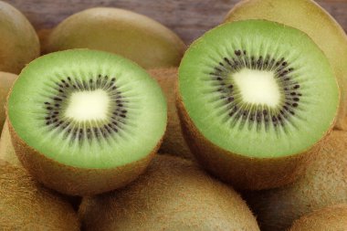 Green kiwi fruit and some cut ones clipart