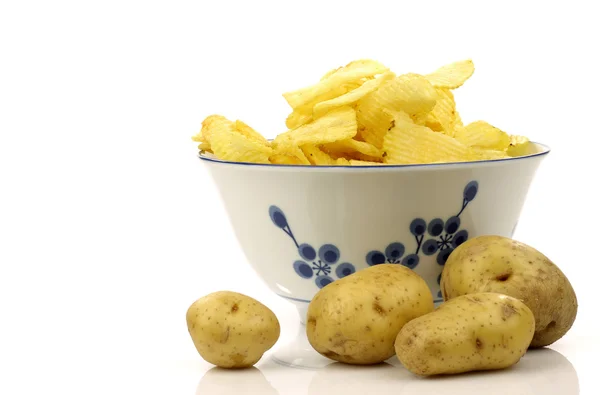 Decorated bowl with fresh potato chips and a few potatoes — Stock Photo, Image