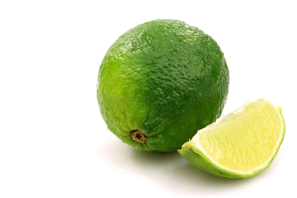One whole lime fruit and a piece — Stock Photo, Image