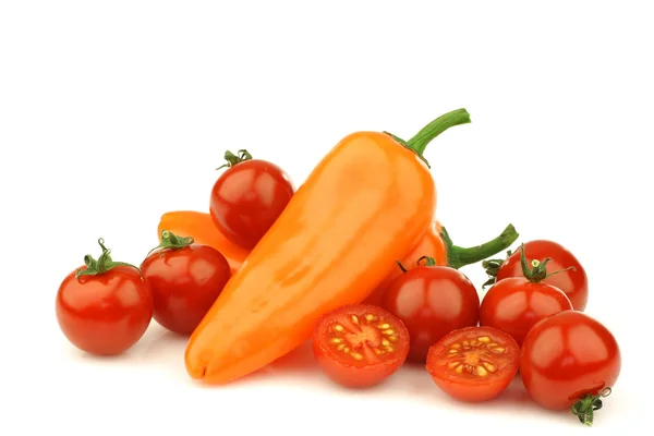 Świeże pomidory na winorośli i dwie papryki pomarańczowy — Zdjęcie stockowe