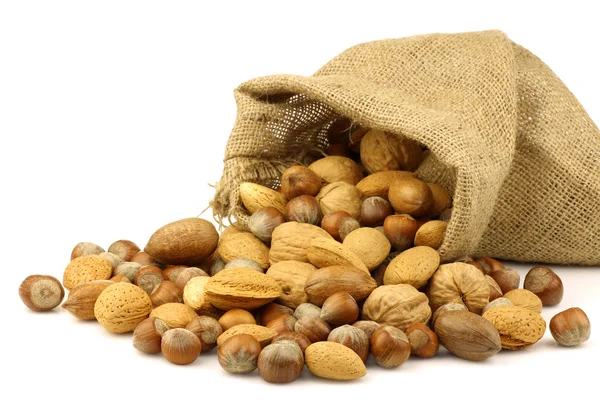 Assorted nuts coming out of a burlap sack — Stock Photo, Image