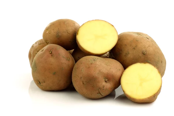 Bunch of potatoes and a cut one — Stock Photo, Image