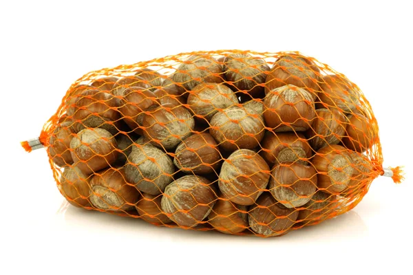 Bunch of fresh hazelnuts in a plastic net — Stock Photo, Image