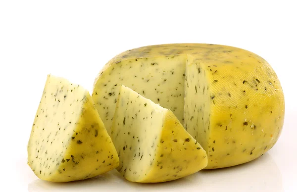 Couper le fromage Gouda traditionnel avec des herbes — Photo