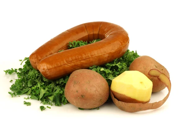 Freshly cut kale cabbage and a smoked sausage — Stock Photo, Image