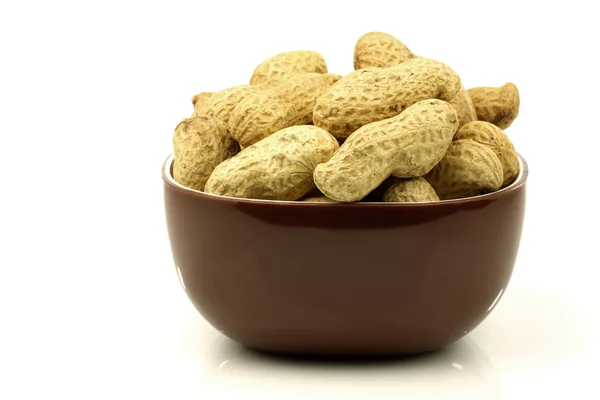 A bunch of fresh roasted peanuts in a brown bowl — Stock Photo, Image