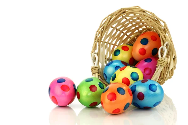 Kleurrijke Pasen eieren afkomstig van een rieten mand — Stockfoto