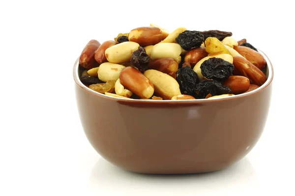 Mixed peanuts and raisins in a brown bowl — Stock Photo, Image