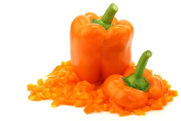 One whole orange bell pepper and a bunch of cut pieces — Stock Photo, Image