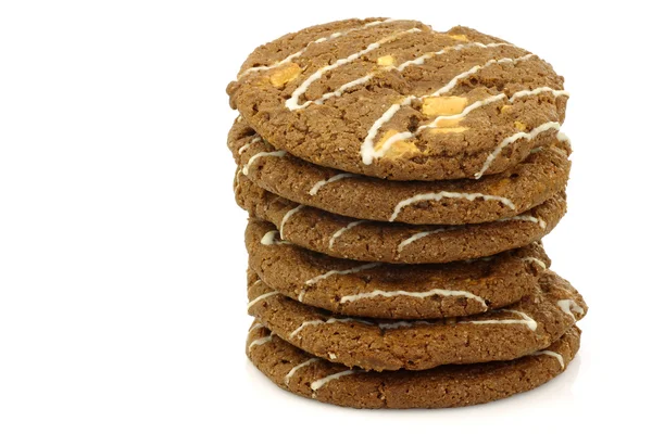 Stacked crunchy chocolate chip cookies with nuts decorated with white chocolate — Stock Photo, Image