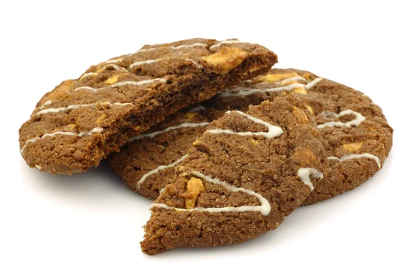En helhet och en bruten choklad chip cookies med nötter dekorerad med vit choklad — Stockfoto