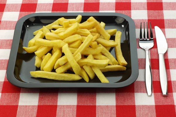 Жареная картошка фри на тарелке со столовыми приборами — стоковое фото