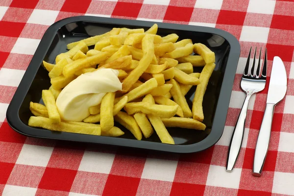 Freshly fried French fries with mayonnaise on a plate with cutlery — Stock Photo, Image