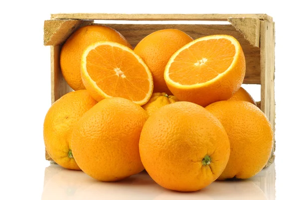 新鲜橘子和一个木箱两半 — 图库照片
