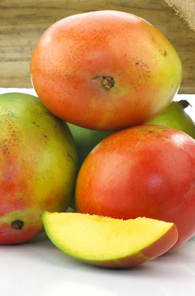 Свежие фрукты манго и порез в деревянной коробке — стоковое фото