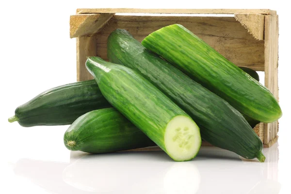 Verse komkommers en een verlaging van één in een houten doos — Stockfoto