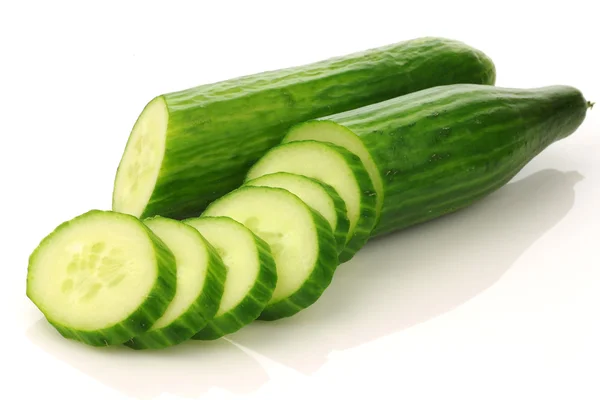 Two cut cucumber halves and some pieces — Stock Photo, Image