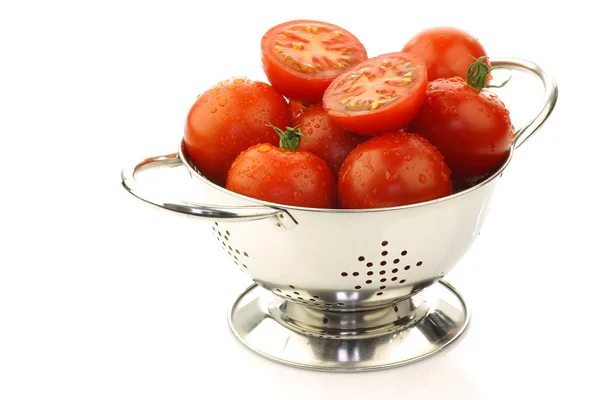 Tomates frescos y uno cortado en un colador de metal —  Fotos de Stock
