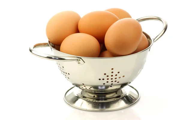 Fresh brown eggs in a metal colander — Stock Photo, Image