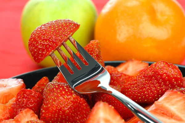 Schwarzer Teller mit frisch geschnittenen Erdbeeren — Stockfoto