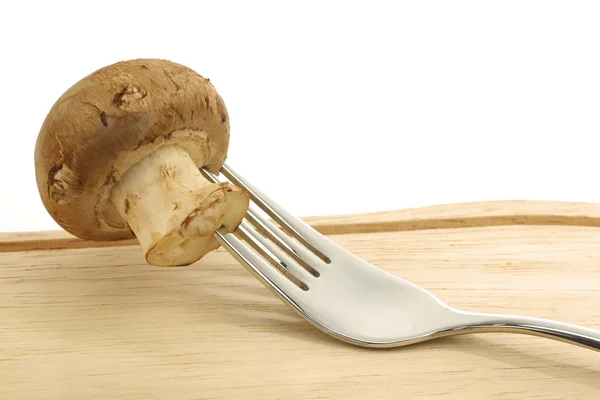 Fresh whole champignon mushroom on a fork — Stock Photo, Image