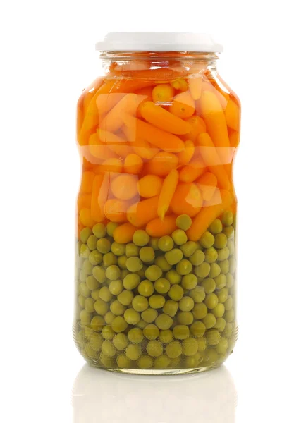 Zanahorias frescas y guisantes verdes en un frasco de vidrio —  Fotos de Stock