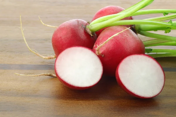 Fresh radishes and a cut one — Stock Photo, Image