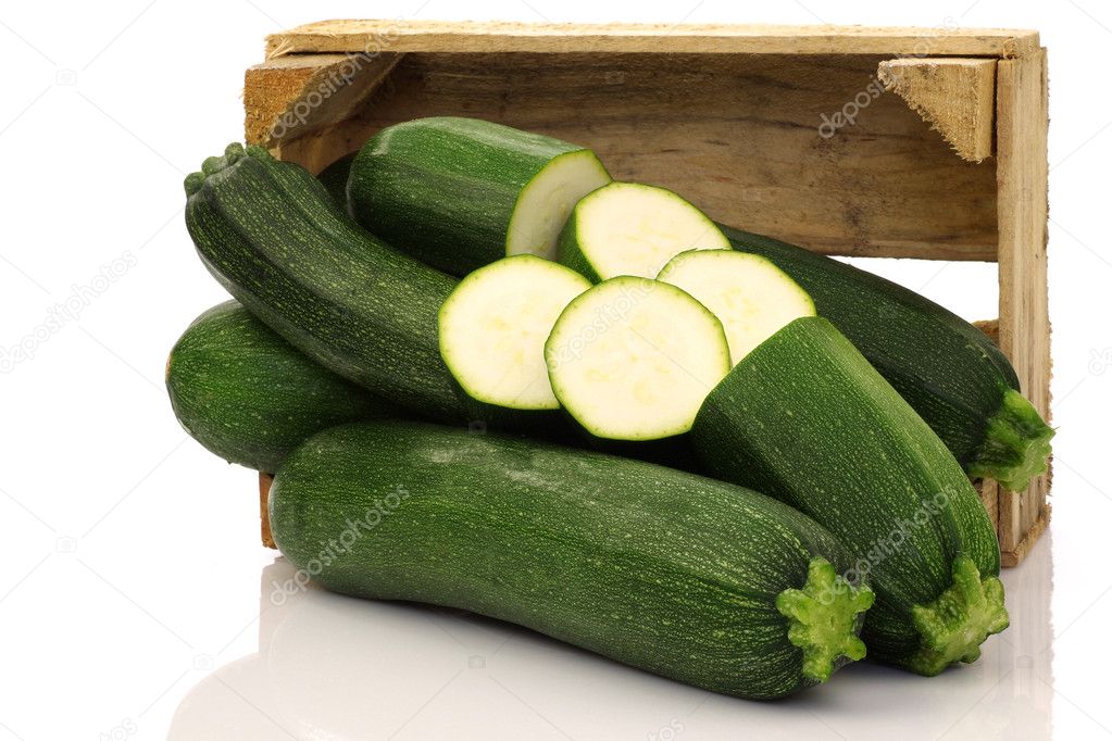 Fresh zucchini's and a cut one in a wooden box