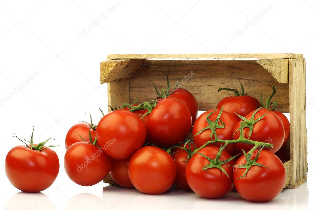 Fresh tomatoes on the vine in a wooden crate