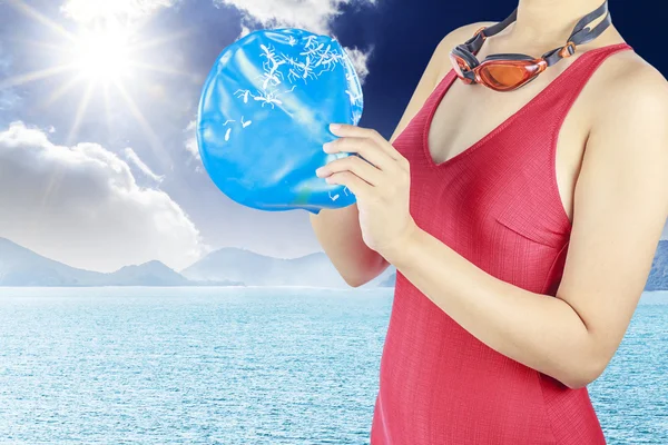 Молодая женщина в красном купальнике и с плавательной шапкой на море b — стоковое фото