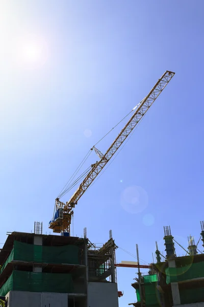 Construcción de grúas y edificios en construcción contra el cielo azul — Foto de Stock