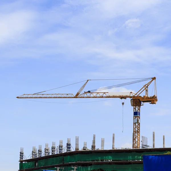 Mavi gökyüzüne karşı inşaat halindeki vinç ve bina — Stok fotoğraf