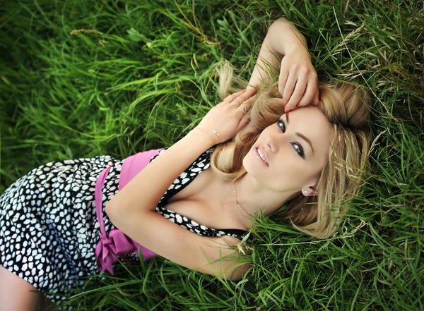 Retrato de mulher bonita jovem em uma grama — Fotografia de Stock