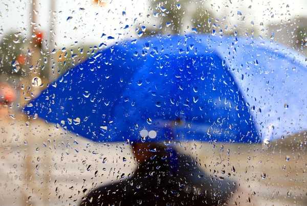Man met blauw paraplu Stockafbeelding