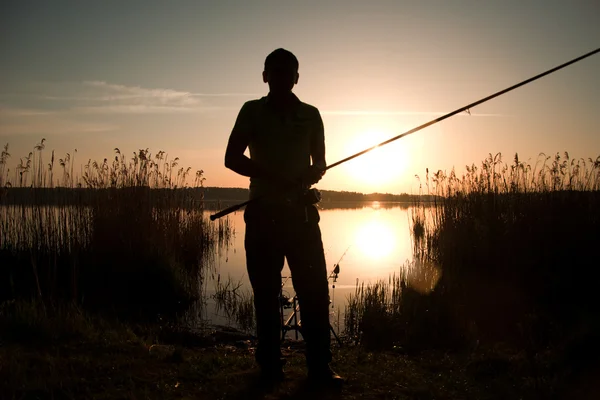 O pescador pesca em um pôr-do-sol — Fotografia de Stock