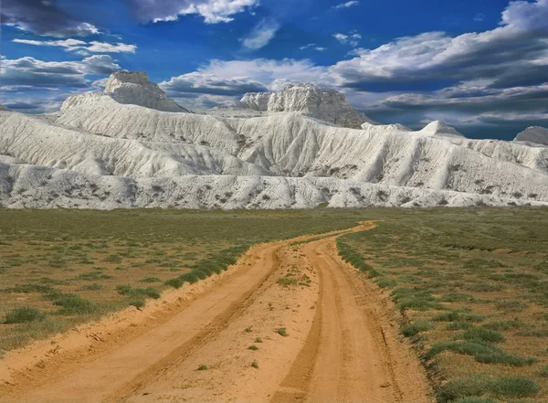 Дорога исчезает в белых горах — стоковое фото