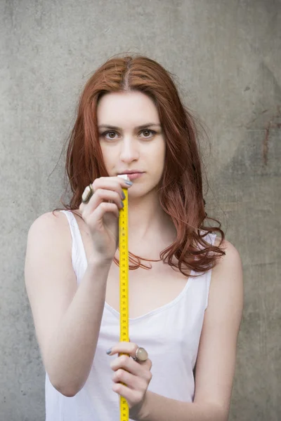 Młoda kobieta trzyma taśma pomiarowa — Zdjęcie stockowe
