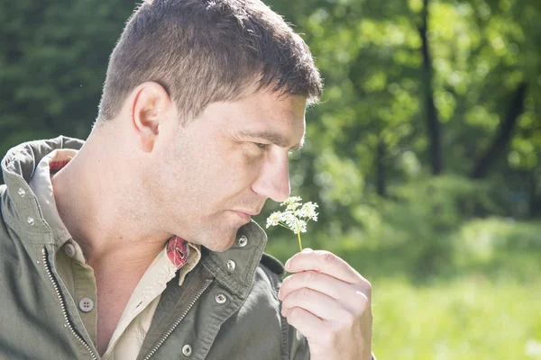 Mann pflückt eine Blume lizenzfreie Stockfotos
