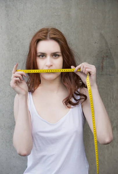 Mujer joven sosteniendo cinta métrica Fotos de stock